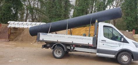 SEH Landscapes Ltd truck transporting a large drainage pipe. Expert landscape gardening services in East Sussex and Kent. Reliable and professional.